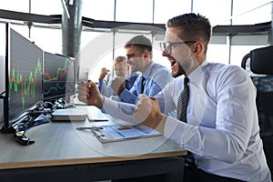 Group of modern business men in formalwear analyzing stock market data while working in the office