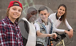 Group of modern teenagers posing and smiling in yard