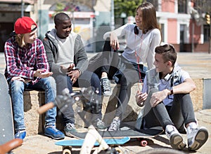 Group of modern teens chatting in the yard photo