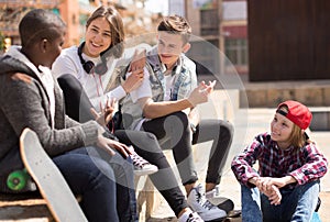 group of modern teens chatting in the yard photo