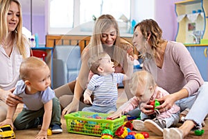 Group of moms and their babies play in day care center