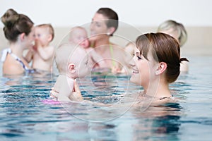 Group of mothers with children at baby swimming lesson