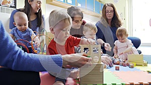 Group Of Mothers And Toddlers Playing With Toys