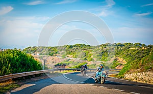 Group of Motorcycles on a winding road by the sea in Sardinia