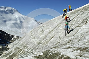 A group of mountaineers climbing down a steep glac