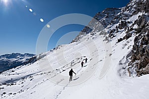 Group of mountaineers walking from the slopes and avalanche danger zone at the top of the mountains