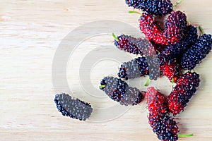 Group of mulberry fruit on the wooden background.