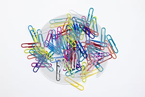 A group of multi-colored paperclips pile up on white background