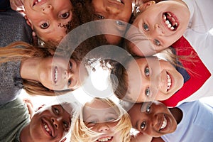 Group Of Multi-Cultural Children With Friends Looking Down Into Camera photo