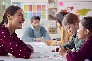 Group Of Multi-Cultural Students With Teachers In Classroom Using Digital Tablet In Lesson