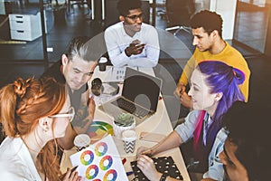 Group of multi ethnic executives discussing during a meeting. Business man and woman sitting around table at office and