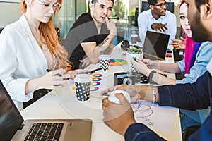 Group of multi ethnic executives discussing during a meeting. Business man and woman sitting around table at office and