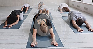 Group of multi-ethnic people resting after workout performing Balasana