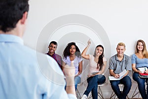 Group of multi ethnic students listening to teacher