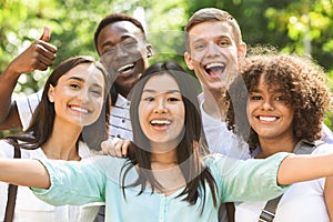 Group of multi-ethnic teen friends taking selfie picture outdoors