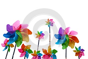 A group of multicolored a garden windmill with colorful wind spinners on white isolated backdround