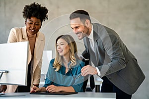 Group of multiethnic business people analyzing data using computer while working in the office