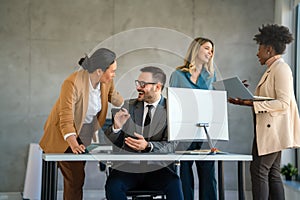 Group of multiethnic business people analyzing data using computer while working in the office