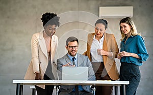 Group of multiethnic business people analyzing data using computer while working in the office