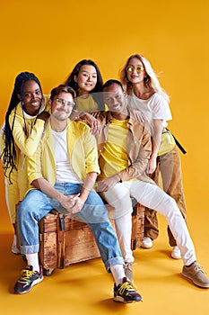 Group of multiethnic friends, people of different cultures isolated on yellow background