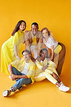 Group of multiethnic friends, people of different cultures isolated on yellow background