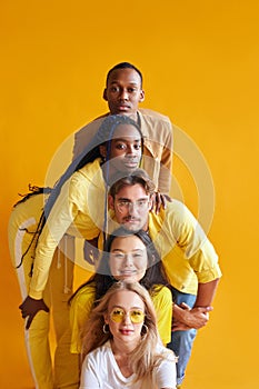 Group of multiethnic friends, people of different cultures isolated on yellow background