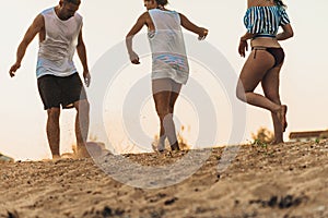 Group of multiethnic friends playing soccer on the beach