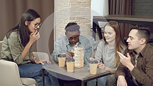 Group of multiethnic happy friends playing block removal game and having fun together at home