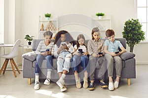 Group of multiethnic kids playing online games on mobile phones and ignoring real life