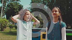 Group of multiethnic kids throwing garbage in recycle dustbin outdoors