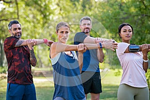 Group of multiethnic mature people stretching arms in park