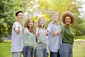 Group Of Multiethnic Teen Friends Standing Outdoors Showing Thumbs Up At Camera
