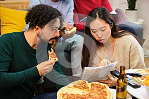 Group of multiethnic university colleagues studying and eating pizza together.
