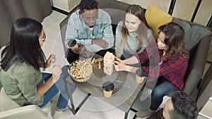 Group of multinational friends playing block removal game in the living room at home. Friendship, leisure concept.