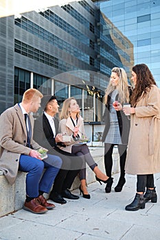 Group of Multiracial businesspeople having lunch outdoor from office building.