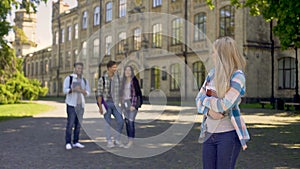 Group of multiracial fellows mocking humble newcomer girl at university