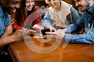 Group of multiracial friends enjoying in cafe together. Young people meeting in a cafe. Young men and women sitting at