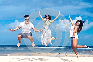 Group of multiracial friends having fun on the beach of tropical Bali island, Indonesia.