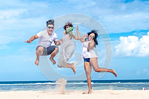 Group of multiracial friends having fun on the beach of tropical Bali island, Indonesia.