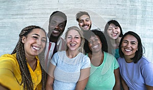 Group multiracial friends having fun outdoor - Happy mixed race people taking selfie together photo