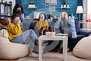 Group of multiracial friends watching horror show on tv