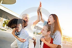 Group of multiracial group of friends having fun in piggyback. Happy young people enjoying together outdoors