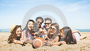 Group of multiracial happy friends having fun playing sport beach games - International concept of summer joy and multicultural f