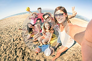 Group of multiracial happy friends taking fun selfie at beach