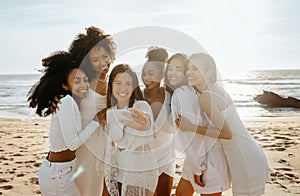 Group of multiracial happy ladies taking selfie on the beach and having fun outdoors, women having bachelorette party
