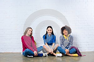 group of multiracial students sitting on floor against white