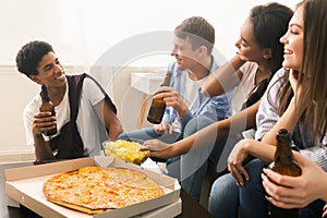 Group of Multiracial Teenagers Sitting Around a Box of Pizza