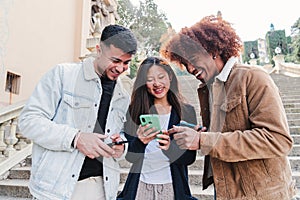 Group of multiracial teenagers watching funny videos on a social media app using a cellphone. Three young friends