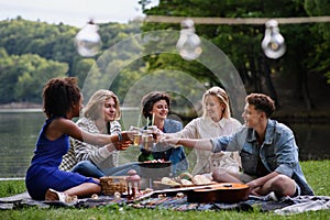 Group of multiracial young friends camping near lake and and having barbecue together.