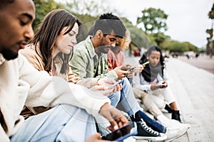 Group of multiracial young friends using smartphone outdoor